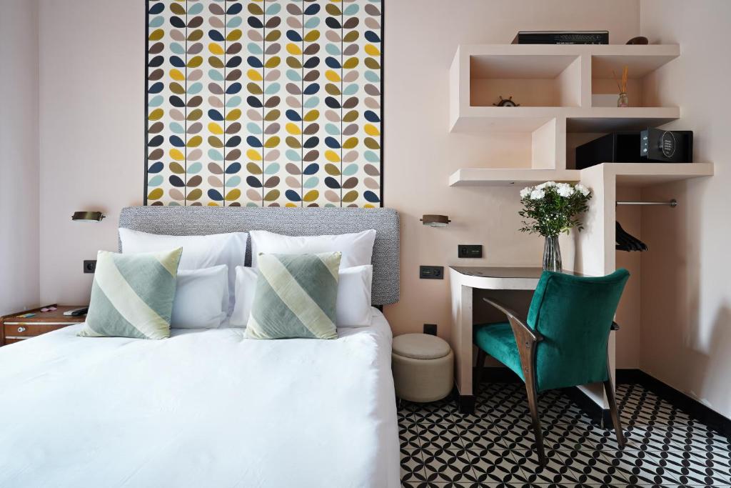um quarto com uma cama, uma secretária e uma cadeira verde em numa l Roca Rooms & Apartments em Barcelona