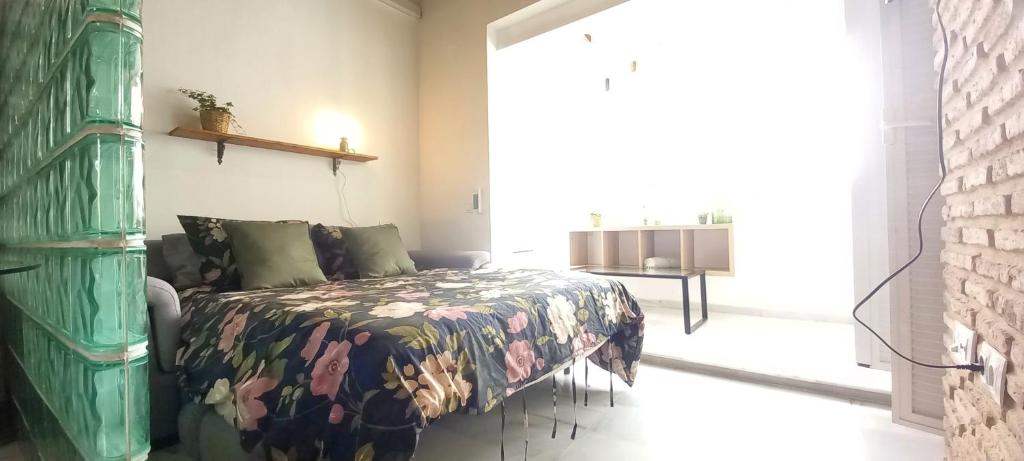 1 dormitorio con 1 cama con colcha de flores en Triana Boho Azotea - ático La Galatea, en Sevilla
