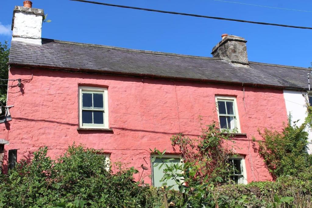 a red house with a black roof at Relaxing 2-Bed Cottage in Rhandirmwyn in Llandovery