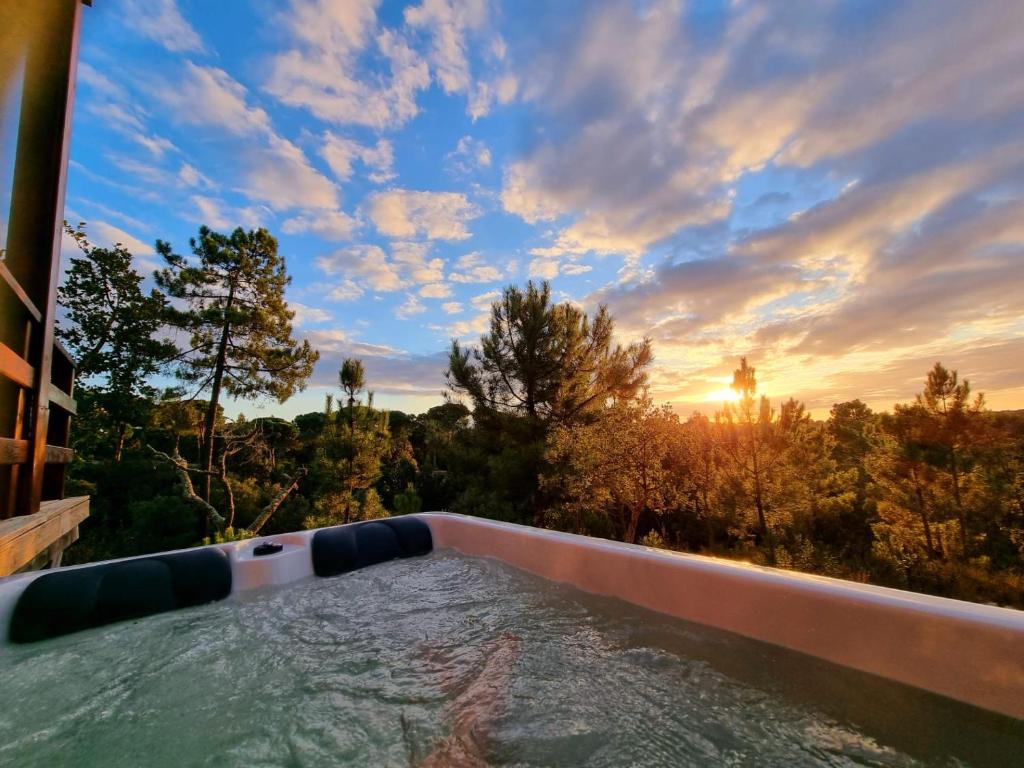 a swimming pool with the sunset in the background at Montum Farm Living in Melides