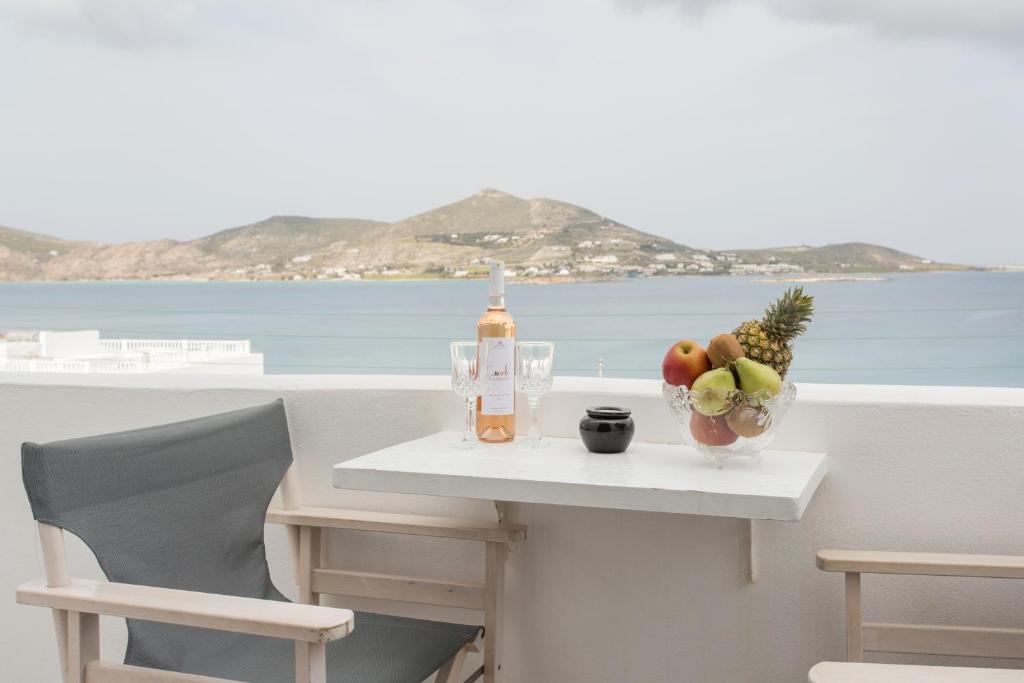 una mesa con un bol de fruta y una botella de vino en Irini Rooms en Naousa