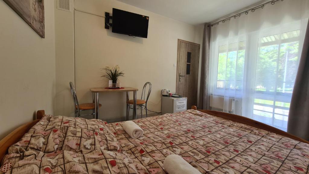 1 dormitorio con cama, mesa y ventana en Dom Wypoczynkowy JOANNA, en Dziwnów