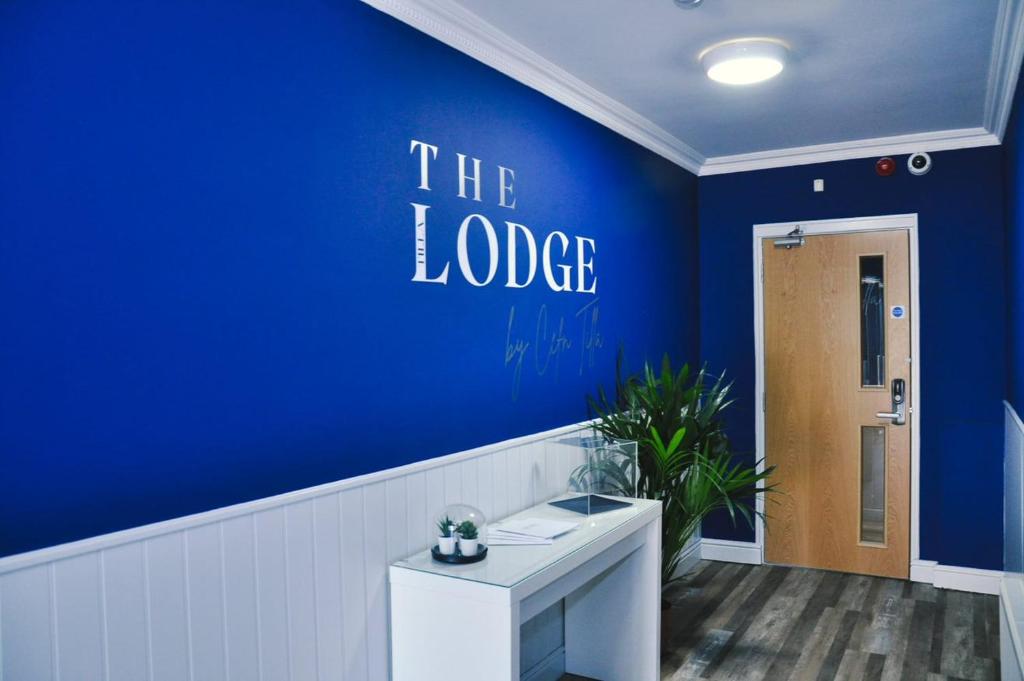 a room with a blue wall with the lobby at The Lodge by Cefn Tilla in Usk
