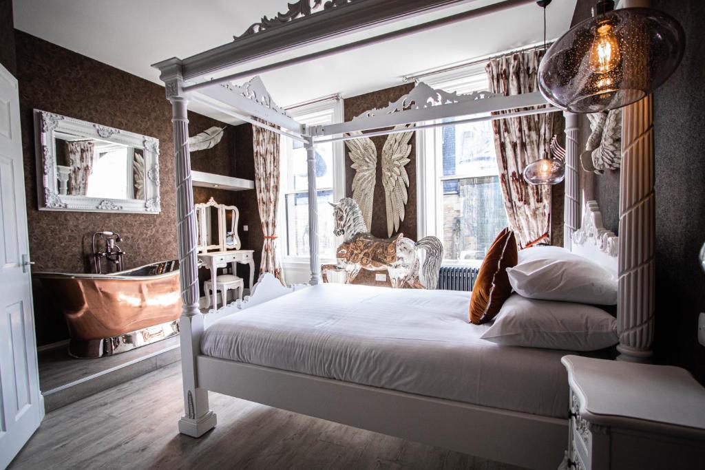 a bedroom with a canopy bed and a bath tub at The Auction House in Morpeth