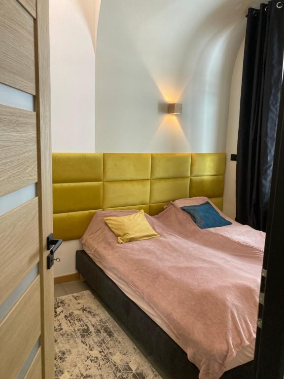 a bedroom with a bed with a yellow headboard at Schweizerhaus Apartments in Karpacz