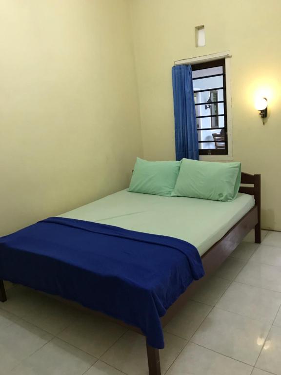 ein kleines Bett in einem Zimmer mit Fenster in der Unterkunft OYO 90998 Wisma Pinggir in Tanjung Pinang 