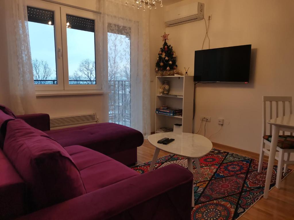 uma sala de estar com um sofá roxo e uma mesa em Bellavista em Vrnjačka Banja