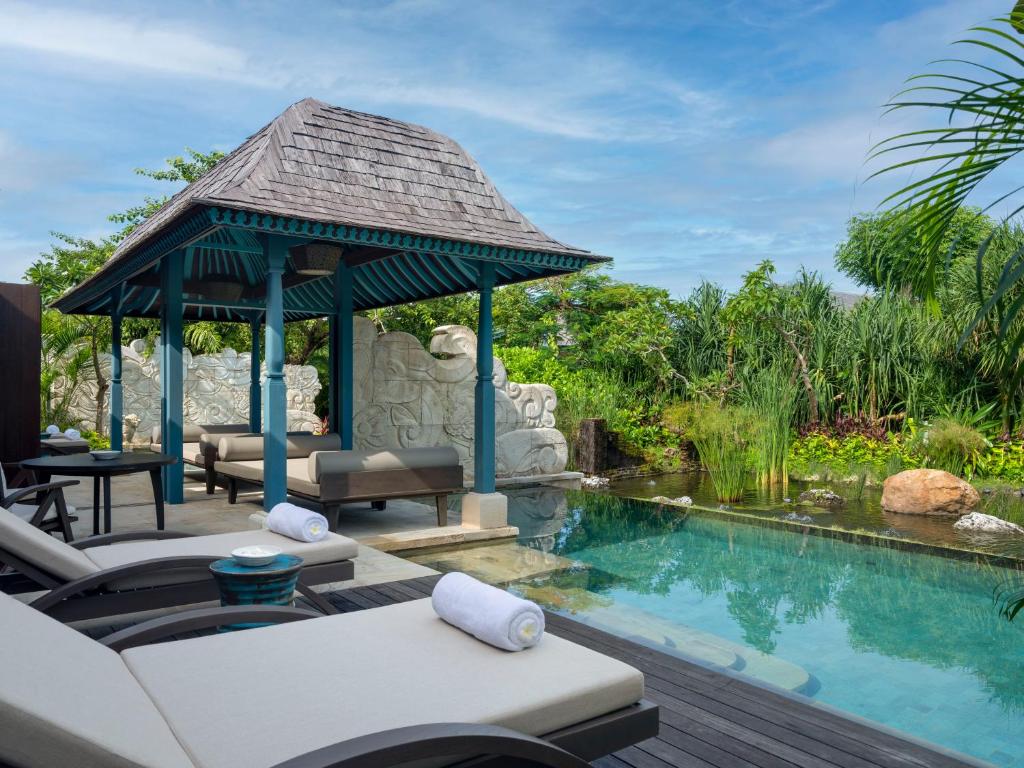 a patio with a gazebo next to a swimming pool at Jumeirah Bali in Uluwatu