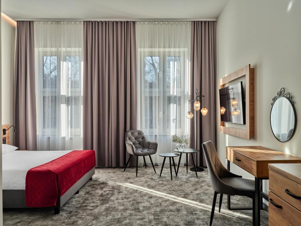 a hotel room with a bed and a desk at 1891 Garni Hotel in Kraków