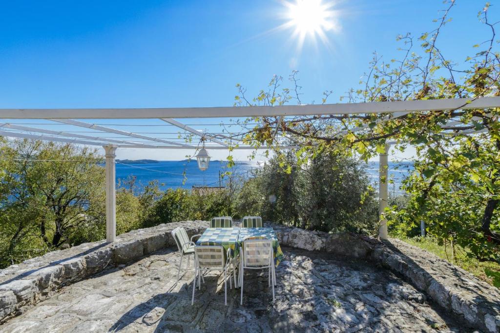 una mesa y sillas bajo una pérgola con vistas en Villa Soline, en Mlini