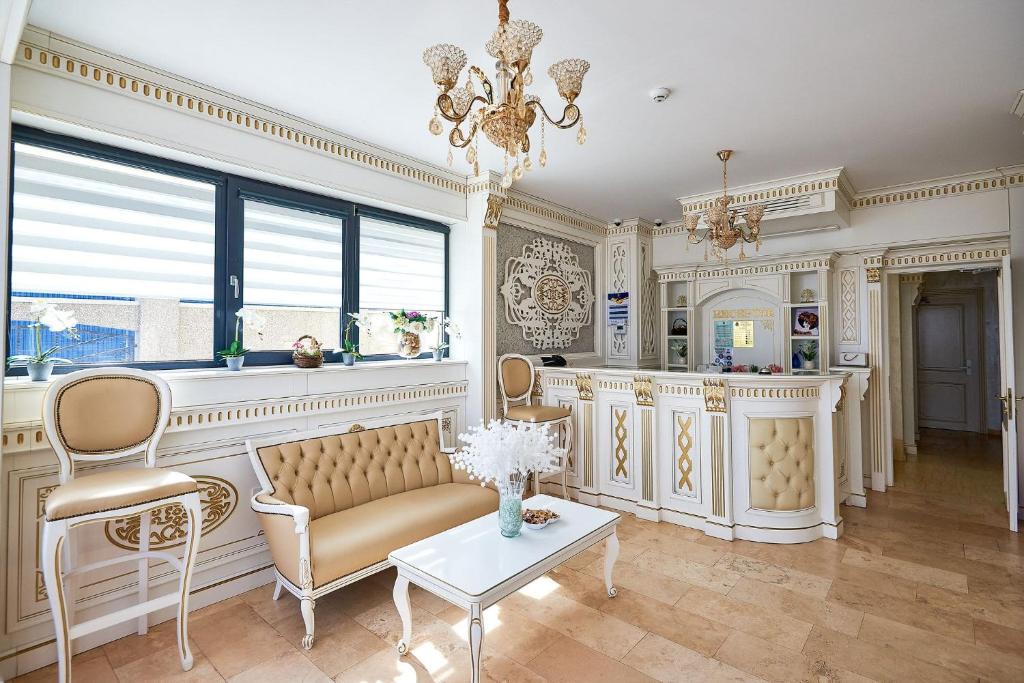 a living room with a couch and a table and a chandelier at HOTEL ADRIANO in Brăila