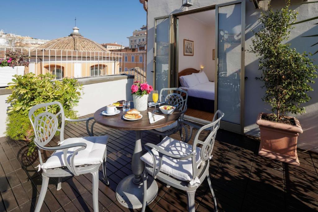 een patio met een tafel en stoelen op een balkon bij Hotel Raffaello - Sure Hotel Collection by Best Western in Rome