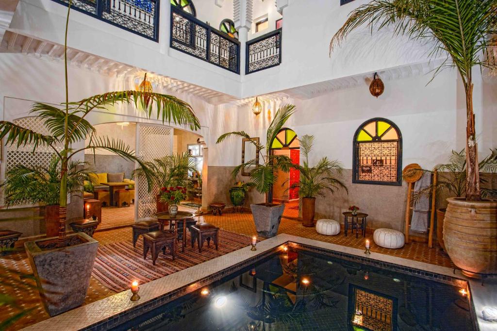 een huis met zwembad in een kamer met palmbomen bij Riad Dabachi in Marrakesh