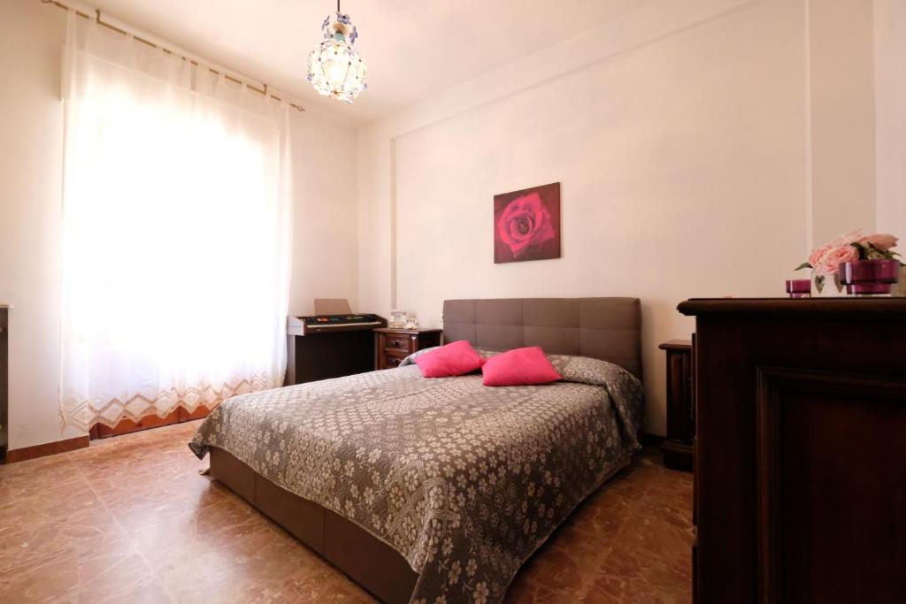 Malibù 5 Pineto Vacanza في بينيتو: غرفة نوم مع سرير مع وسائد وردية عليه
