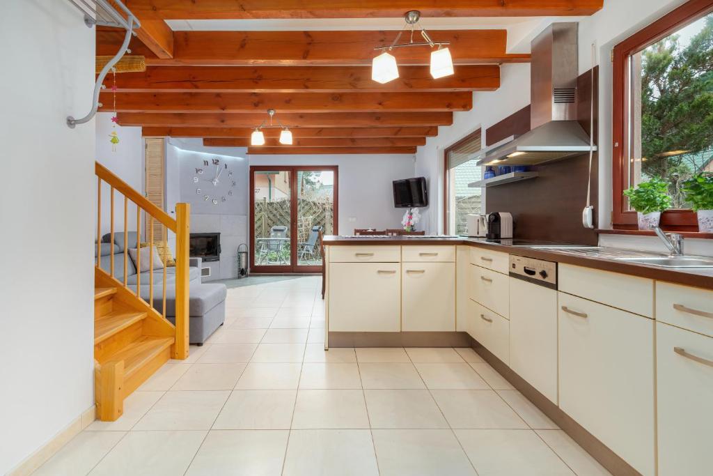 a kitchen with white cabinets and a staircase at Wypoczynek w domu nad morzem in Łukęcin