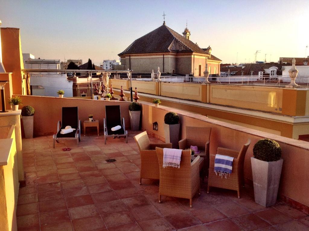 a balcony with chairs and tables on a building at Life Apartments San Vicente in Seville