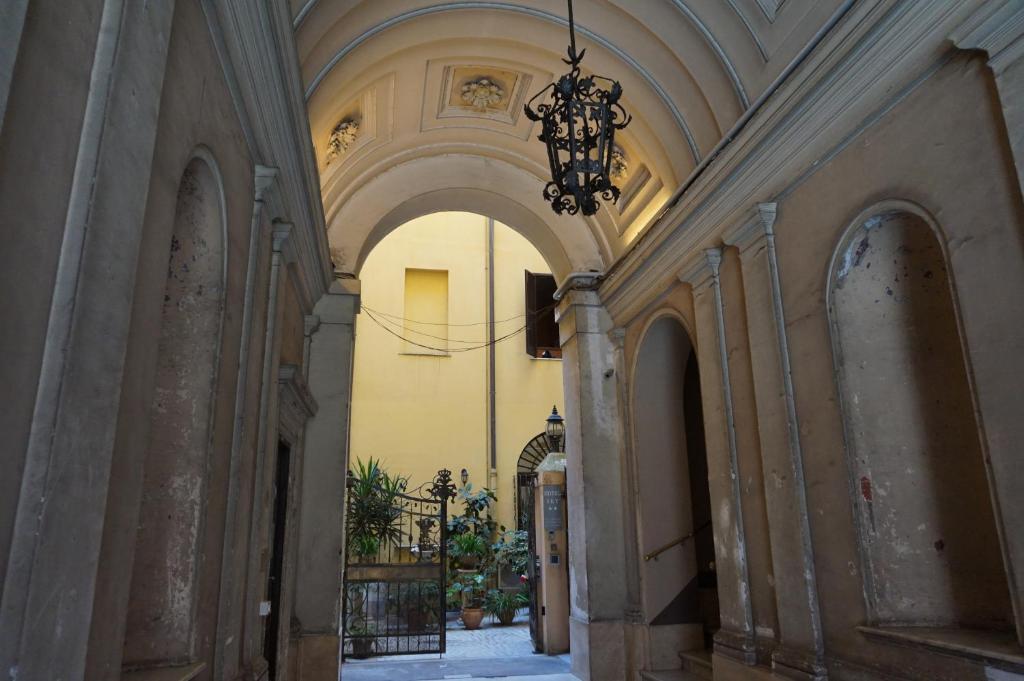 une allée avec un lustre dans un bâtiment dans l'établissement Hotel Filippo, à Rome