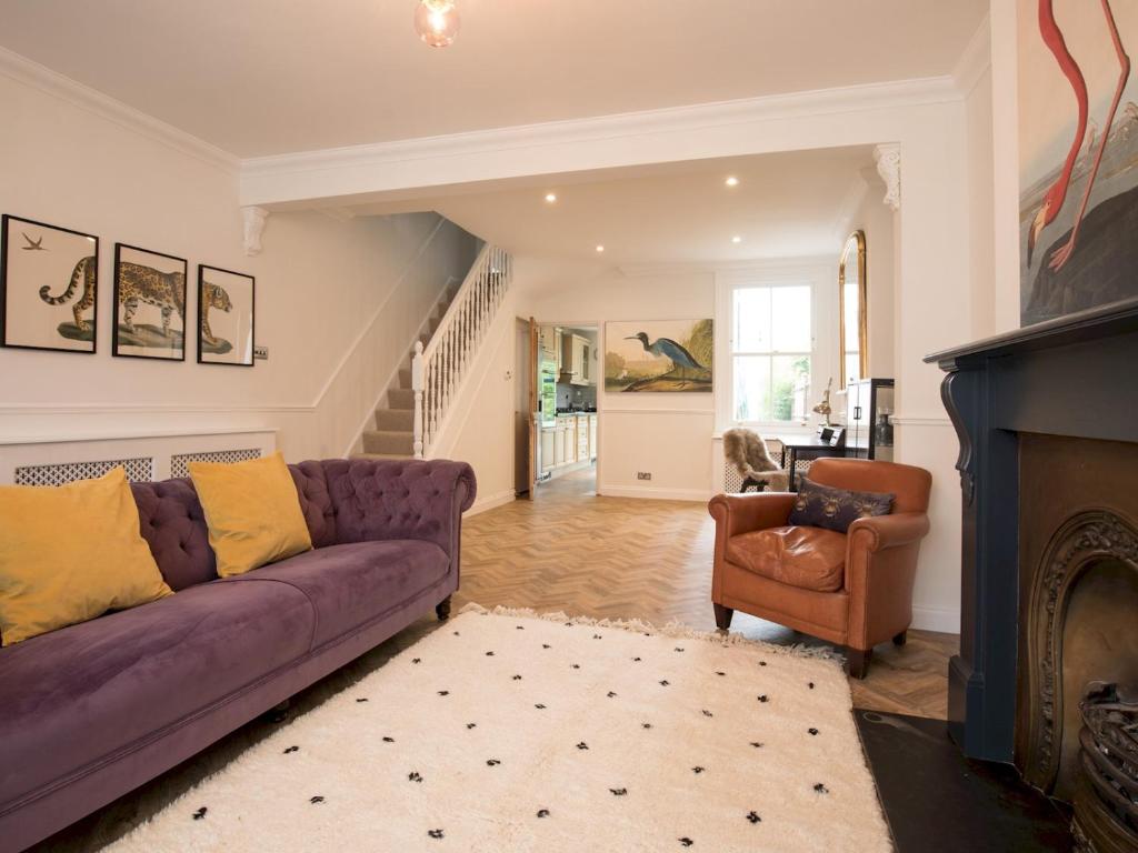 sala de estar con sofá púrpura y chimenea en Pass the Keys Cheerful Roomy 6 Sleeper in Central Windsor with Garden, en Windsor