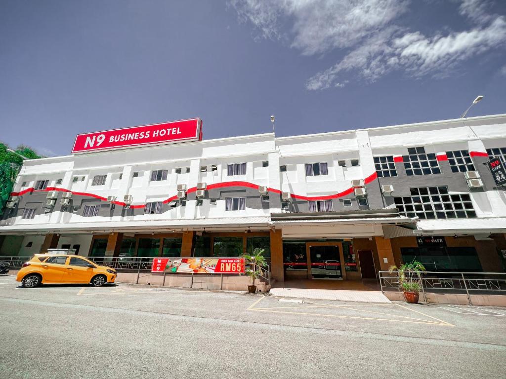 un'auto gialla parcheggiata di fronte a un edificio di N9 Business Hotel Sdn Bhd a Nilai