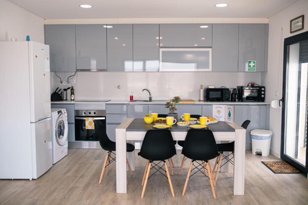 Una cocina con una mesa y sillas en una cocina. en SwordFish Sea View Apartment, en Peniche