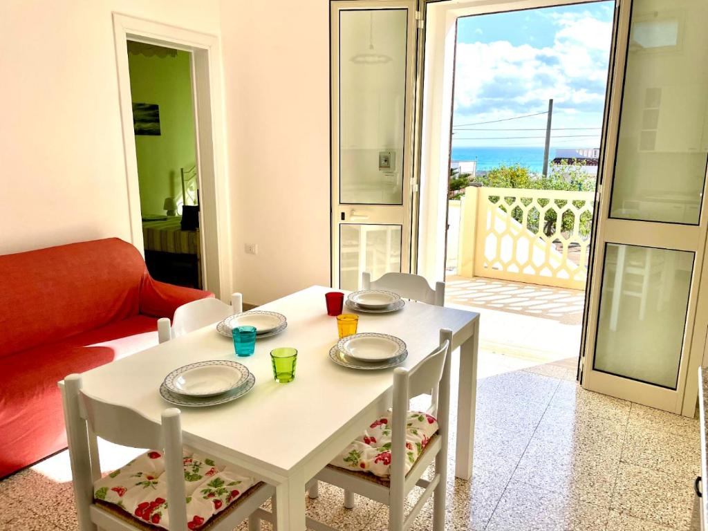 einen weißen Tisch und Stühle mit Meerblick in der Unterkunft Le macchie - Vacanza nel verde in Torre Vado