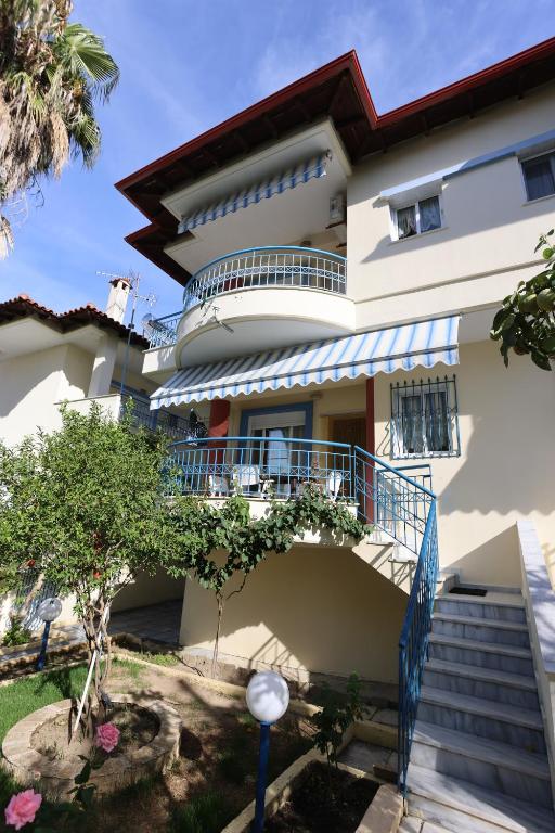 een huis met een balkon en een trap bij Nella Maisonette Hanioti in Hanioti