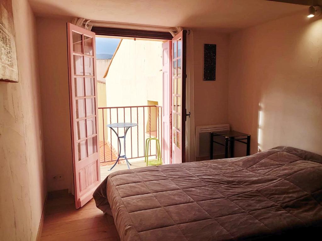 a bedroom with a door open to a balcony at 6MIR17 - Chaleureuse maison de pêcheurs idéalement située in Collioure