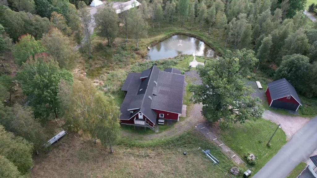 eine Luftansicht eines Hauses mit einem Teich in der Unterkunft Loft Ålaryd in Skillingaryd