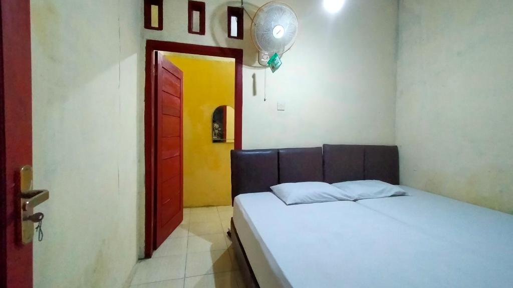 a bedroom with a bed and a red door at Aqsa Guest House Banjarsari in Banjarsari