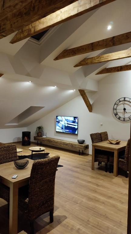 uma sala de estar com pisos em madeira e uma televisão de ecrã plano em LTM apartman em Spišská Nová Ves