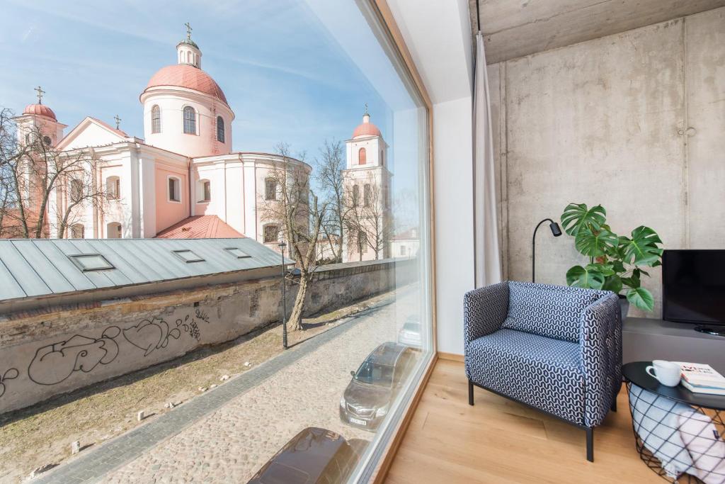 a room with a window with a view of a church at cohost I New Bastėja Life Apartments w-Garage Prkg & Self Check-in in Vilnius