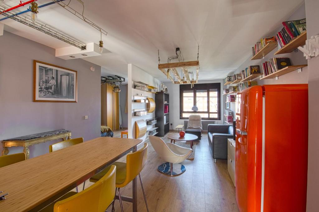 cocina y sala de estar con nevera de color naranja en Loft Gijón, en Gijón