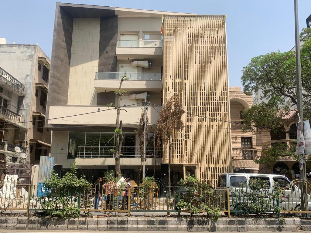 ein hohes Gebäude mit einem Zaun davor in der Unterkunft Hotel Leo Saffron - Corporate Stay Pitampura in Neu-Delhi