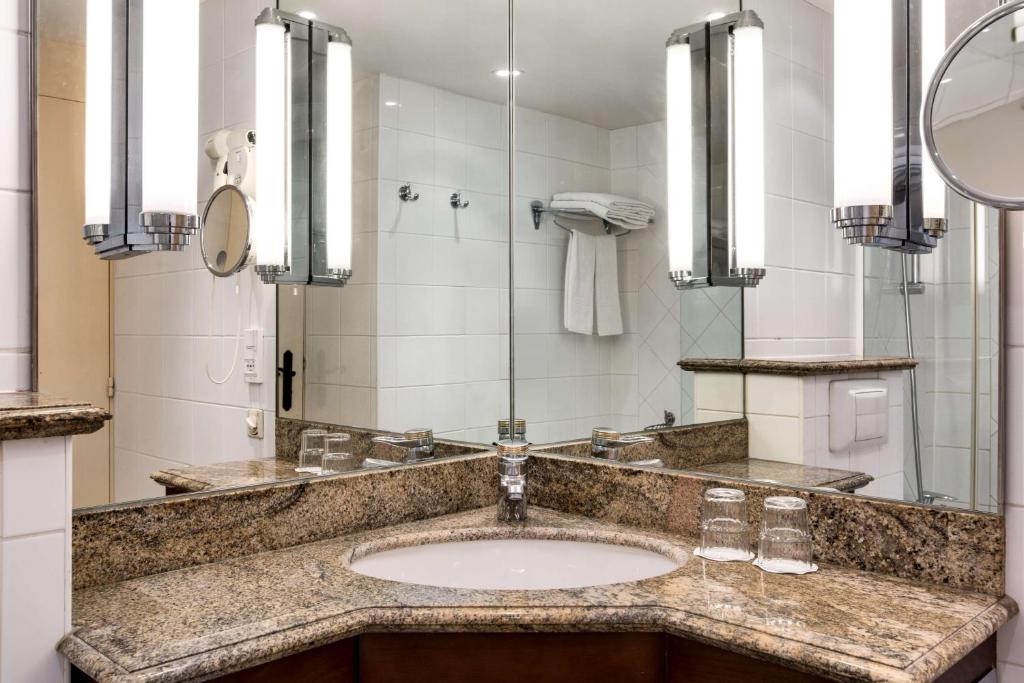 a bathroom with a sink and a mirror at NH Brugge in Bruges