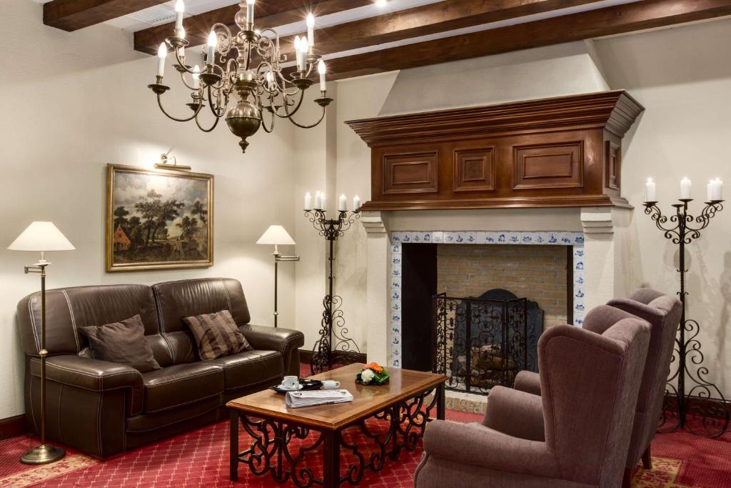 a living room with a couch and a fireplace at NH Brugge in Bruges