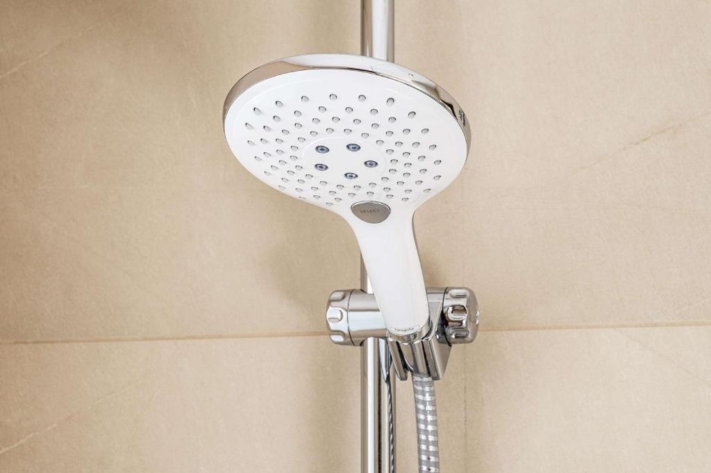a shower with a shower head in a bathroom at NH Brugge in Bruges