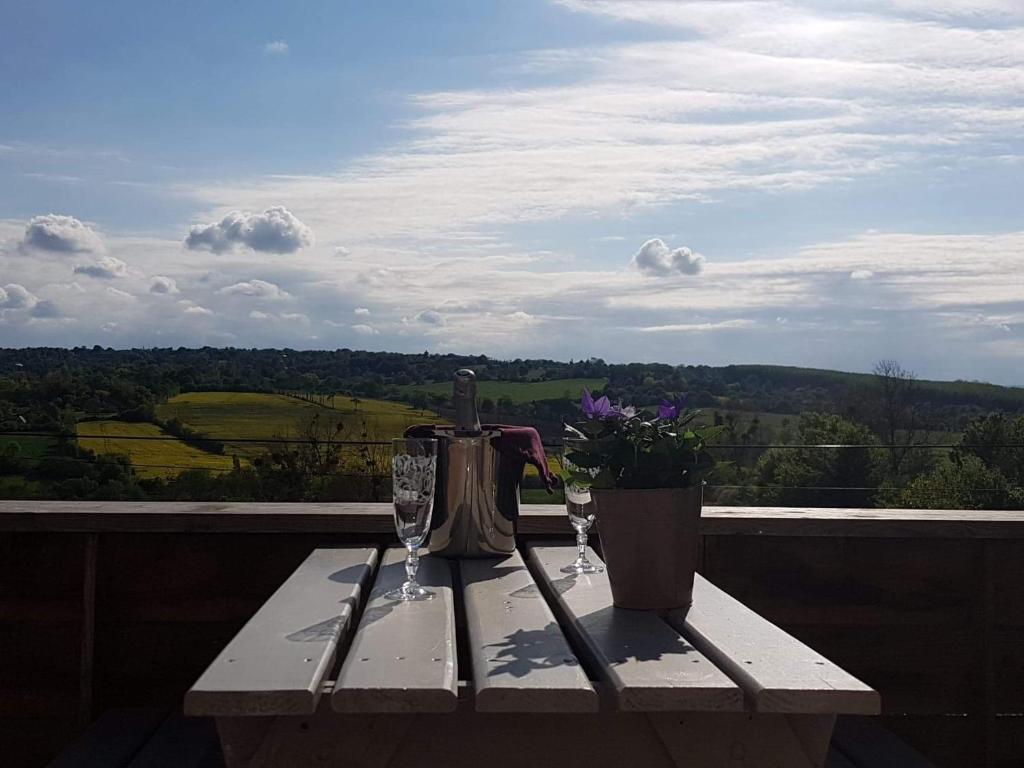 uma mesa com duas taças de vinho e um bule em La Romance Normande gîte balnéo, massages, 2 pers. em Les Authieux-sur-Calonne