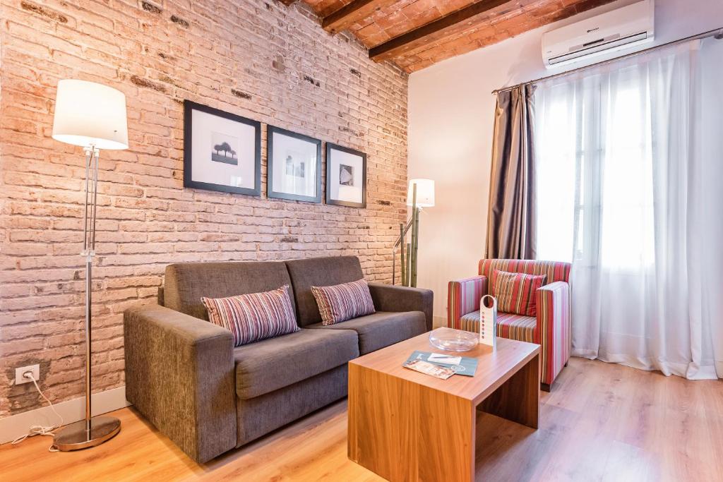 sala de estar con sofá y pared de ladrillo en Sweet Inn - Pare Lainez, en Barcelona