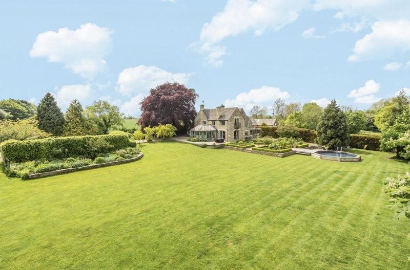 a large grassy yard with a large house at Cotswold Farm- Idyllic location in Stroud