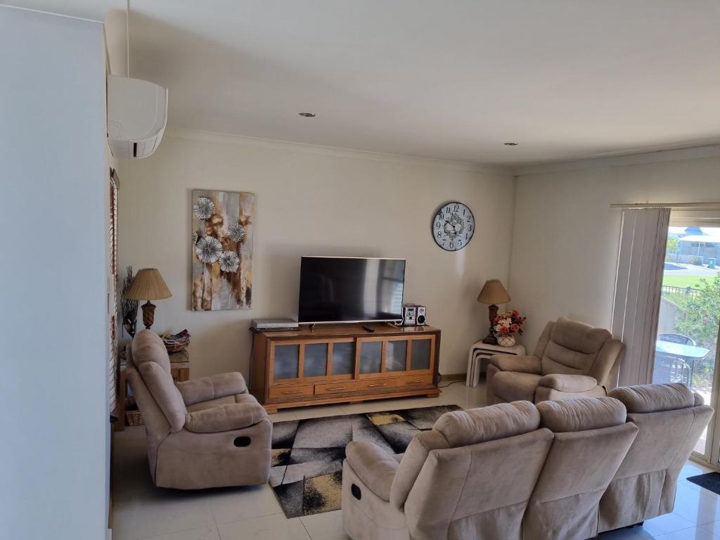 a living room with couches and a flat screen tv at Seafront Unit 25 in Jurien Bay