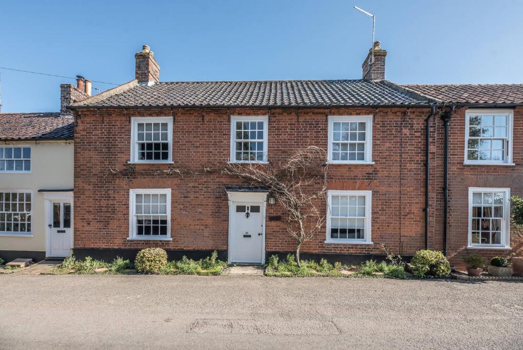 a red brick house with a white door at Baxter House Wangford Air Manage Suffolk in Beccles