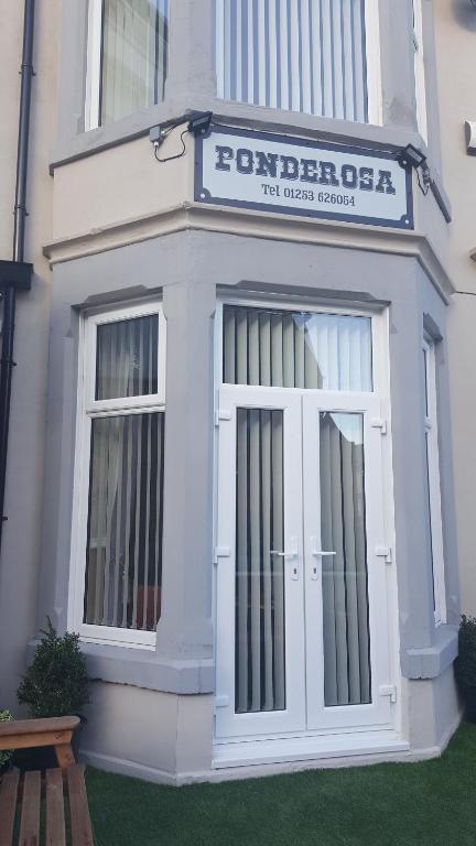 een wit gebouw met een bord boven een deur bij PONDEROSA in Blackpool