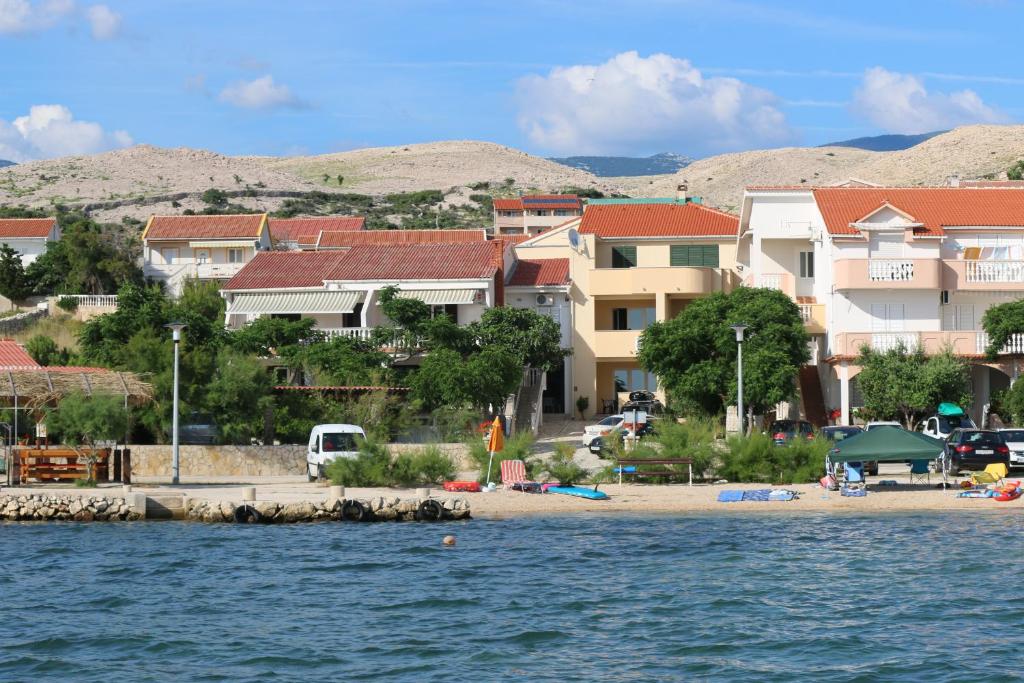a group of buildings on a beach next to the water at Apartments Ana - Kustići in Novalja