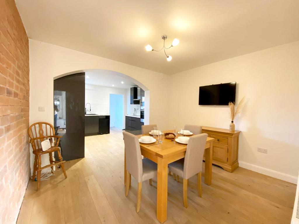 a dining room with a wooden table and chairs at Freshly renovated 2 bedroom Victorian town house. in Hereford