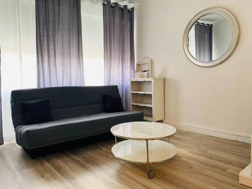 格勒諾布爾的住宿－Le Zen appartement balnéo Grenoble，客厅配有黑色沙发和桌子