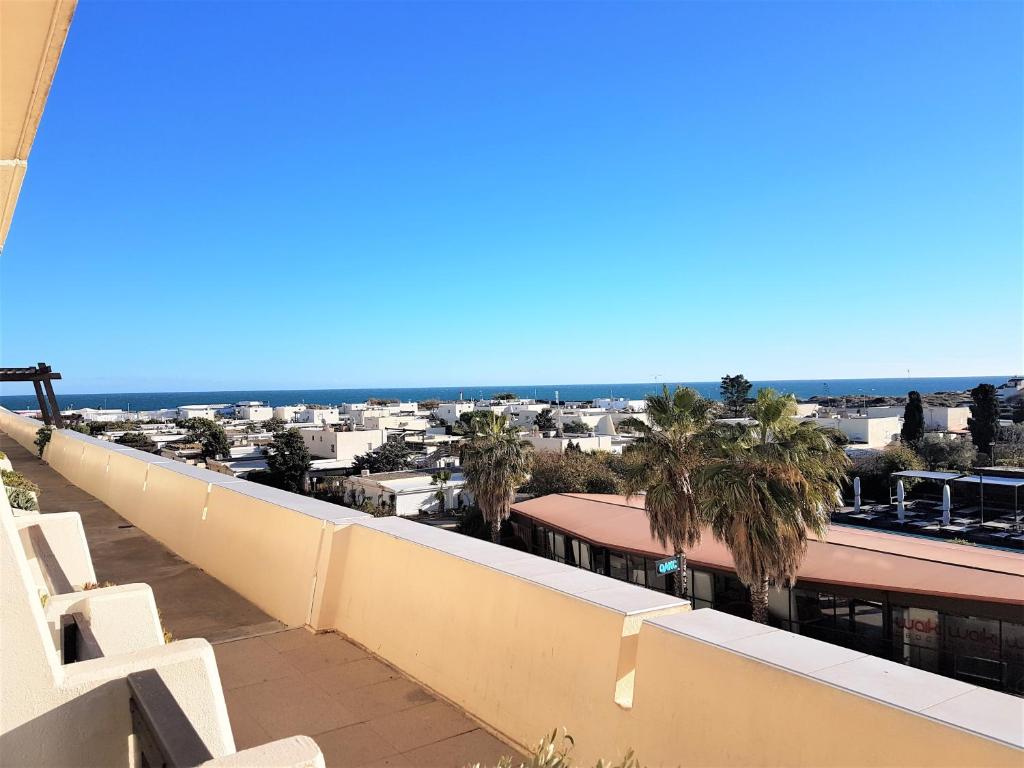 d'un balcon avec vue sur l'océan et les palmiers. dans l'établissement Appartement Village Naturiste Mystere, au Cap d'Agde