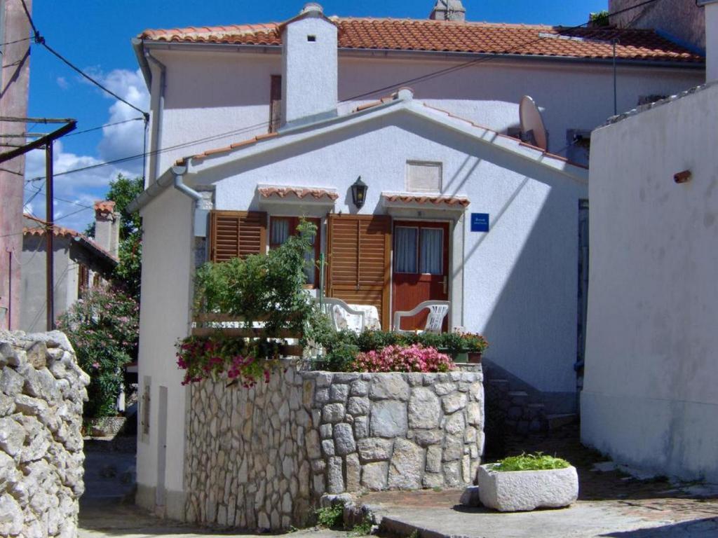 a small white house with a stone wall at Zora Holiday home in Beli