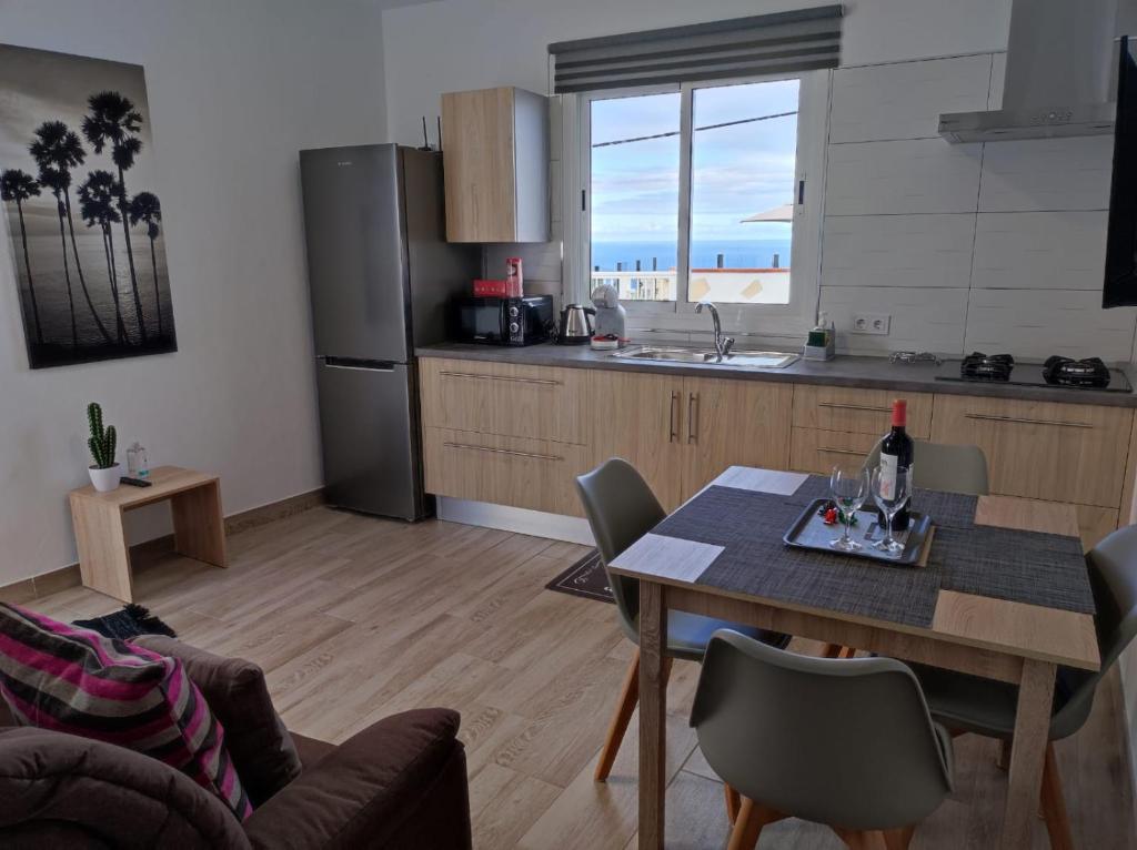 Una cocina y comedor con mesa y una cocina con vista. en CASA PIRÁMIDE 3. Terraza WiFi y Parking Privado, en Icod de los Vinos