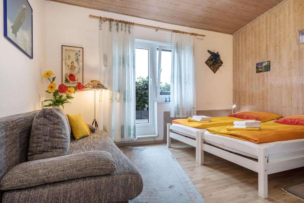 um quarto com uma cama, um sofá e uma janela em Einzimmerwohnung B und E em Meckenbeuren