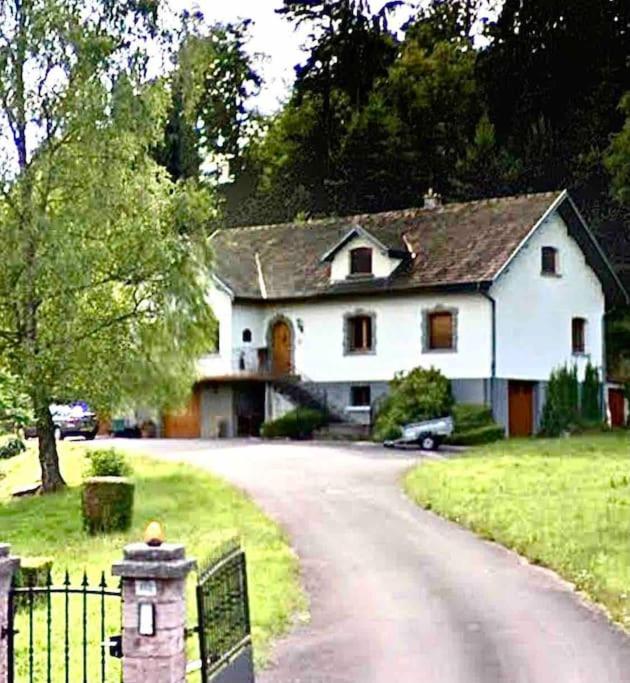 a white house with a gate and a driveway at EVASION gîtes et spa in Saint-Léonard